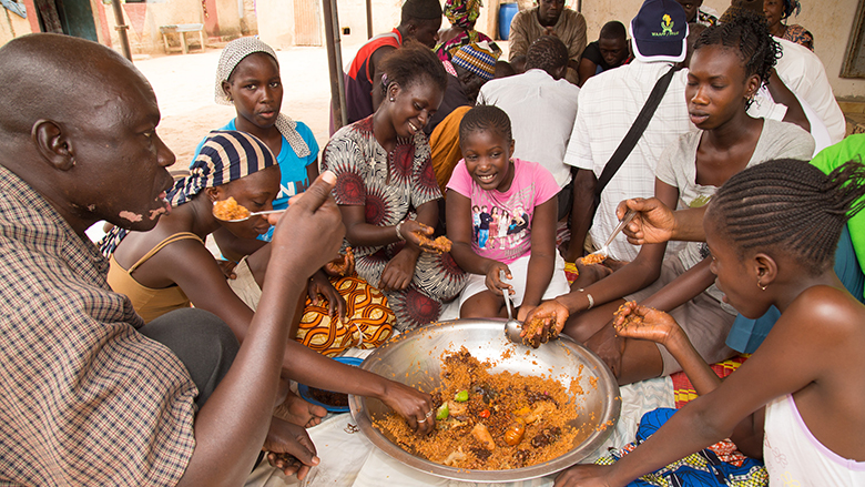 Yalindiaye’s family gathers around a pot of stew, made from one of the new varieties of high-yielding, drought-resistant cowpea. Image