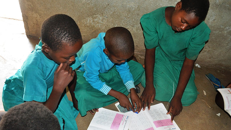 Schoolchildren at Nkasaulo Primary School in Machinga District of Malawi, read their textbooks. The Machinga District is one of several that are benefitting from a program that ensures textbook delivery. 