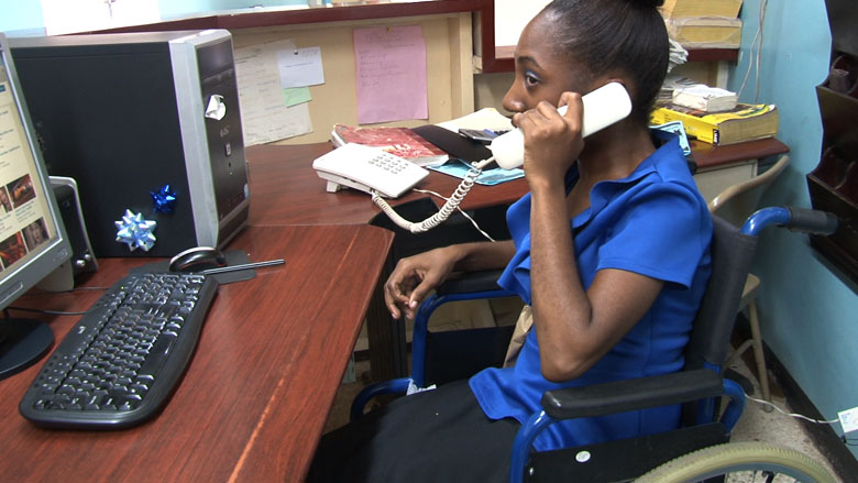 Kavian Moran answers phones at the YMCA in Kingston, Jamaica