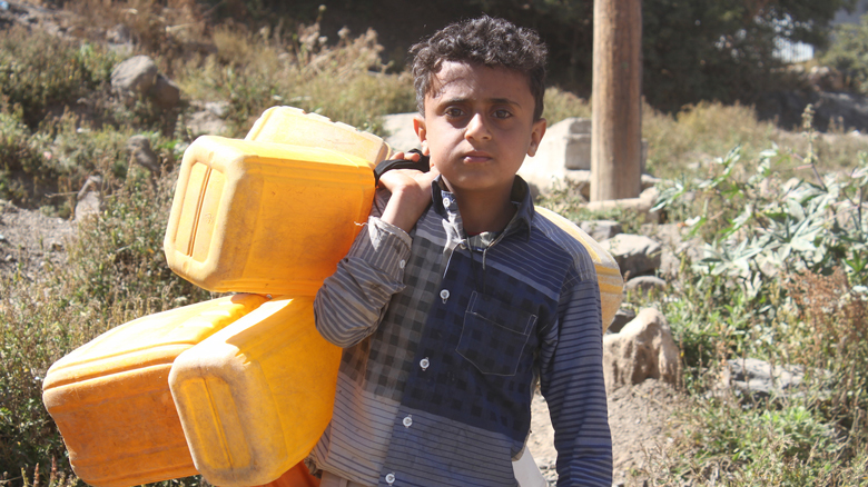  A Yemeni child holds jerry cans of fill it with water.