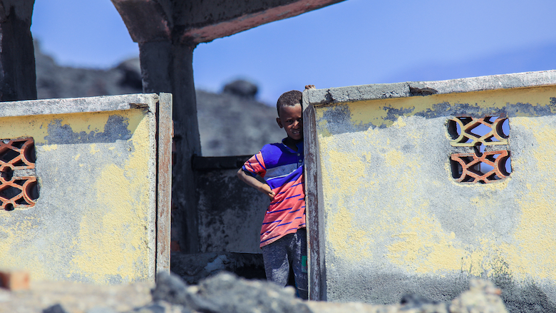 A child stands near a traditional house in Tadjoura, Djibouti.