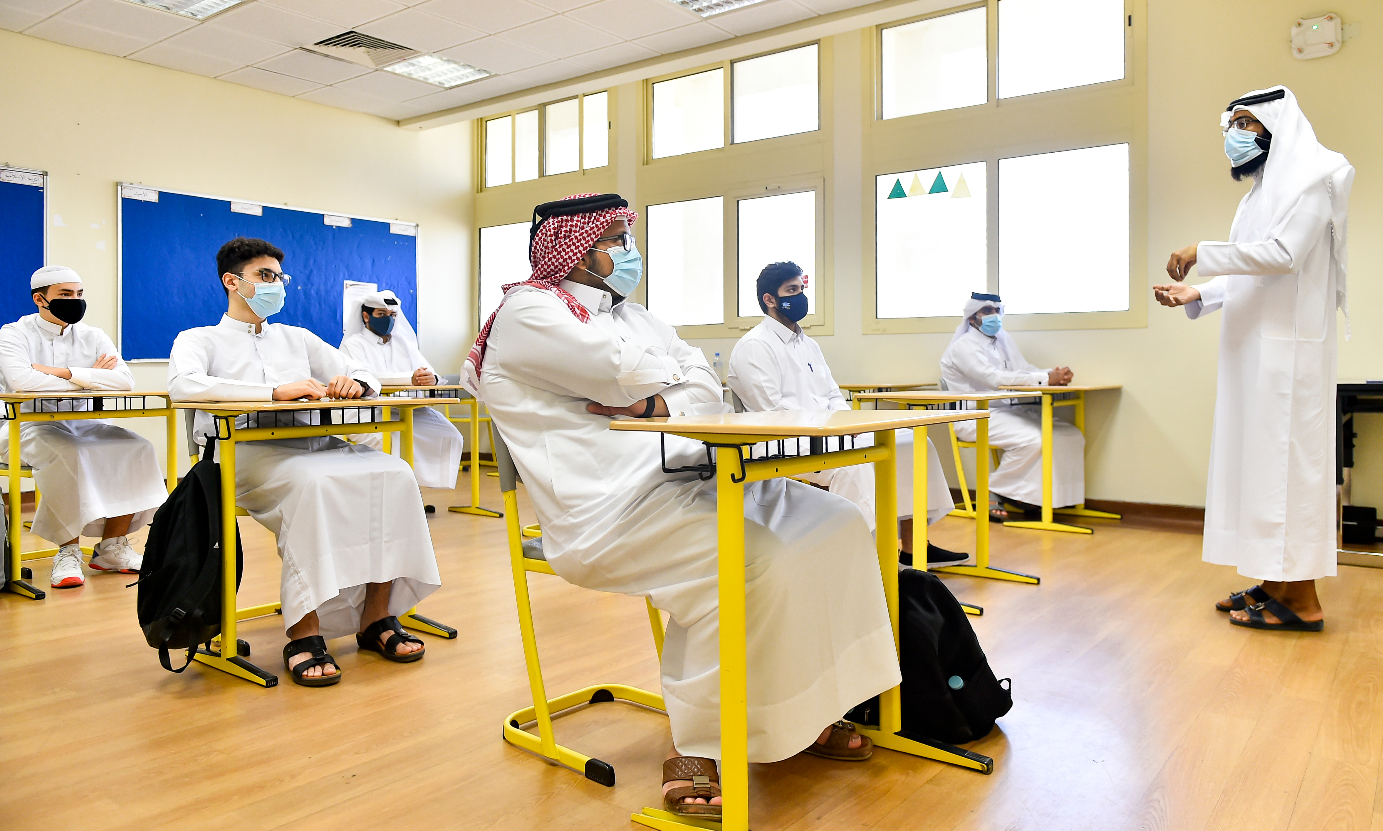 Students wear face masks and maintain social distance in a classroom on the first day of school at a Secondary School in Doha, Qatar.