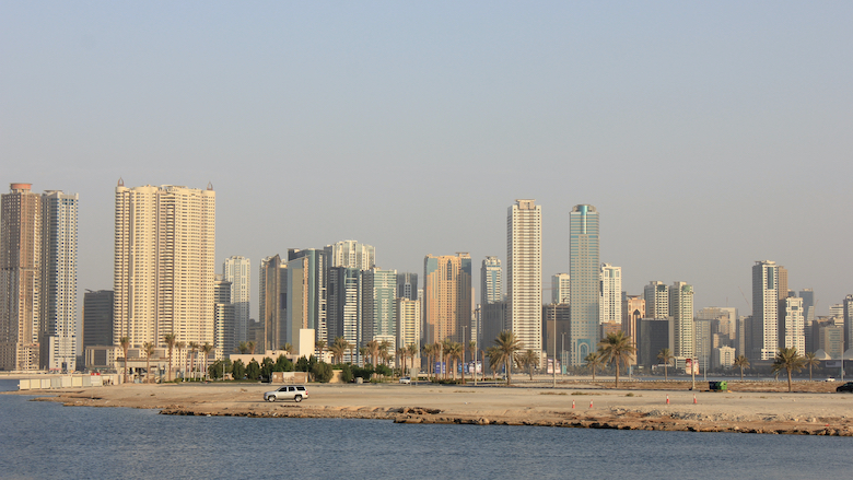 Sharjah city skyline of modern residential buildings/towers can be seen from Al Khan beach overlooking Dubai emirate.