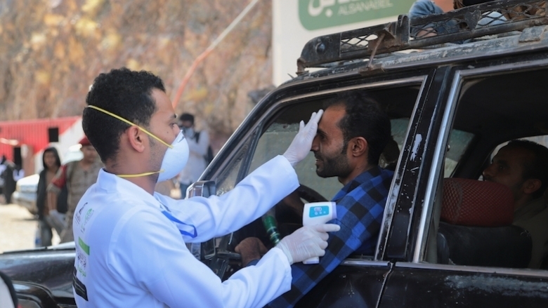A doctor measures the temperature of a driver in the city of Taiz, Yemen.