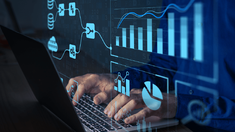 Fingers typing on a computer with data charts