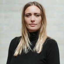 Blonde female with medium hair length wearing black pullover