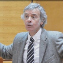 Man with white hair speaking