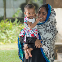 Young Bangladeshi mother holding her child