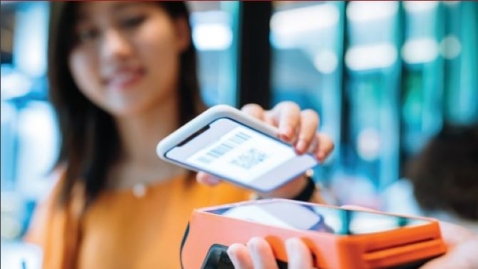 Young Asian woman making purchase with smartphone