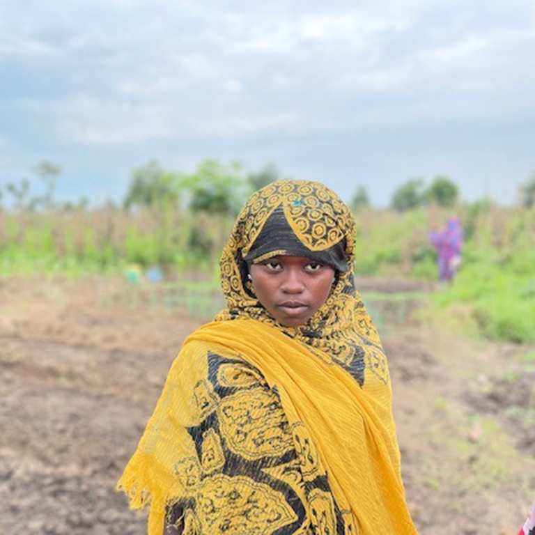 South Sudan - A Sudanese refugee woman standing in front of farm land