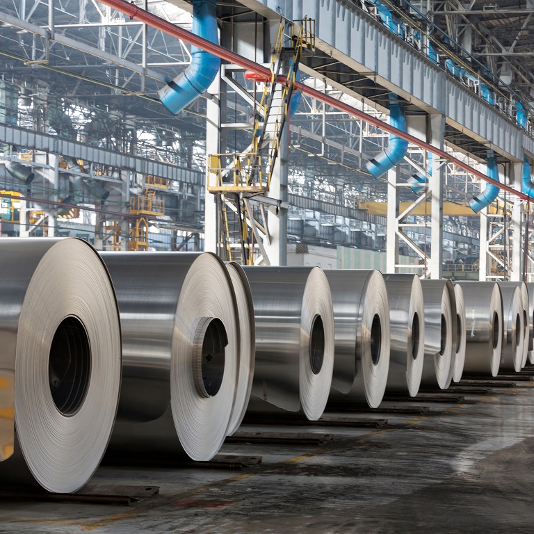 Row of rolls of aluminum lie in production shop of plant