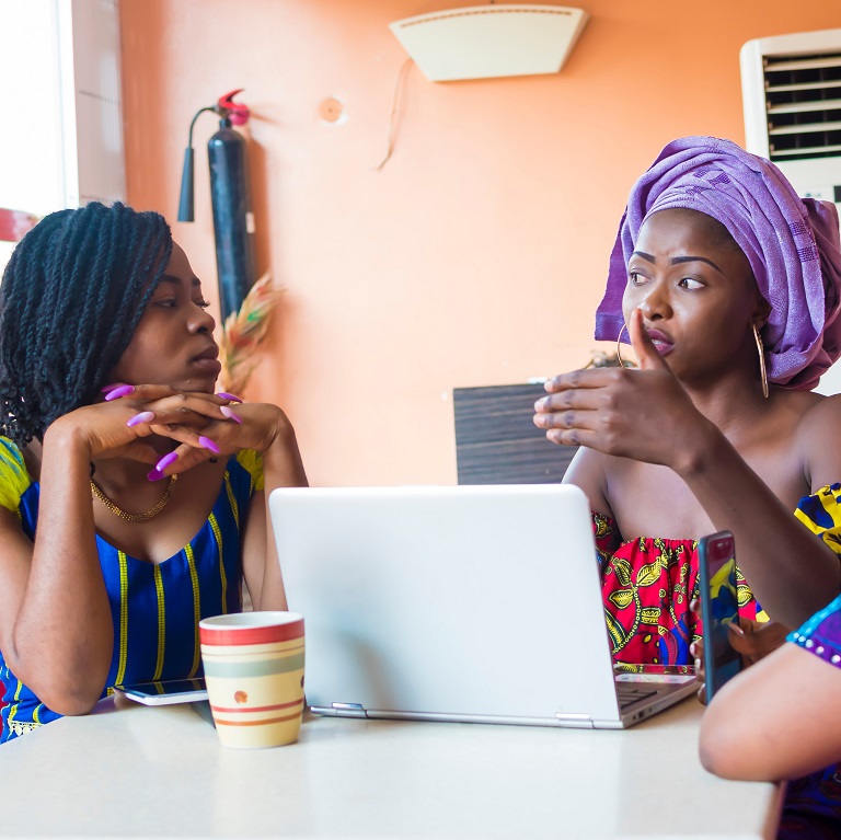 three young African women discussing business.