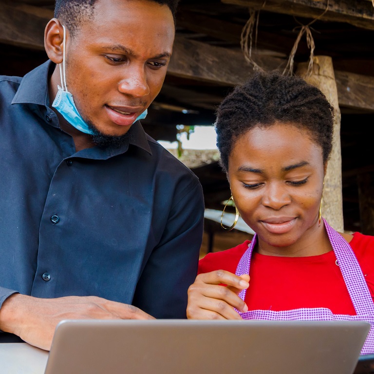 young african business man feels excited as he shows a market woman some information on his laptop.