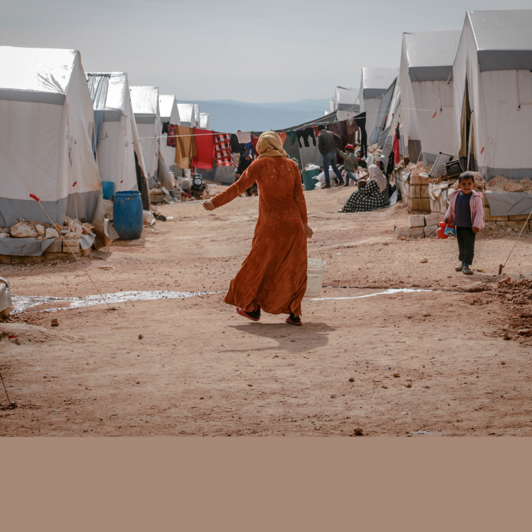 Anonymous woman walking in refugee camp⁠ 