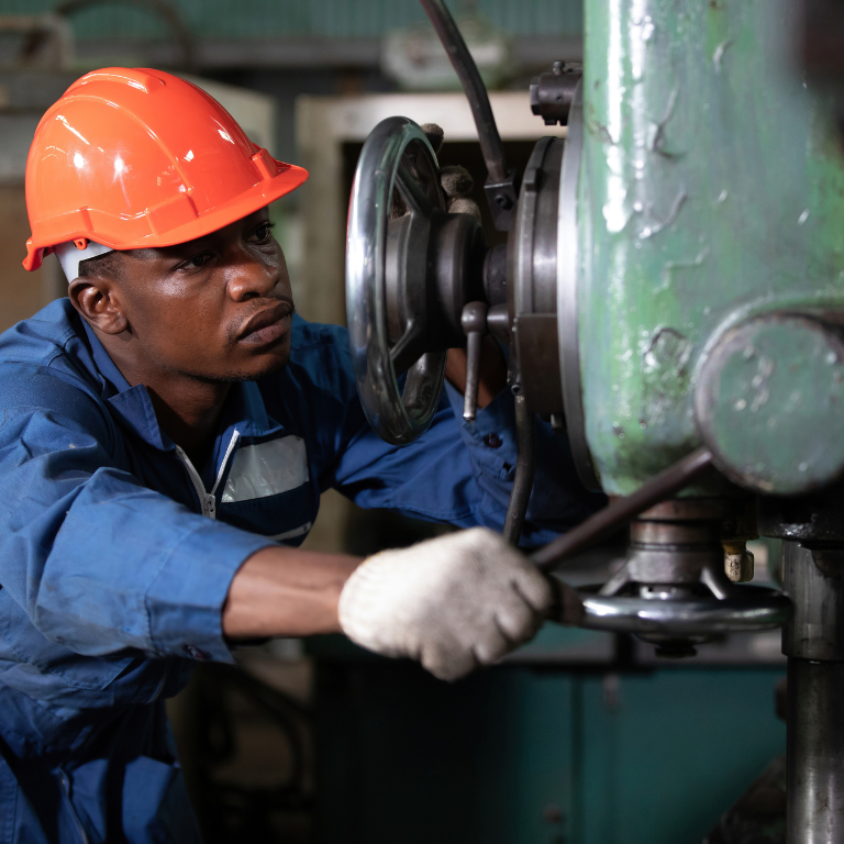 male african workers or technician checking and control lathe machine in factory