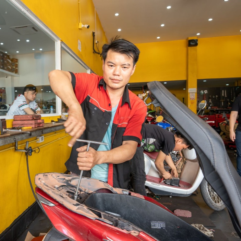 Pan, a motorcycle mechanic, at work in Vientiane, Laos.