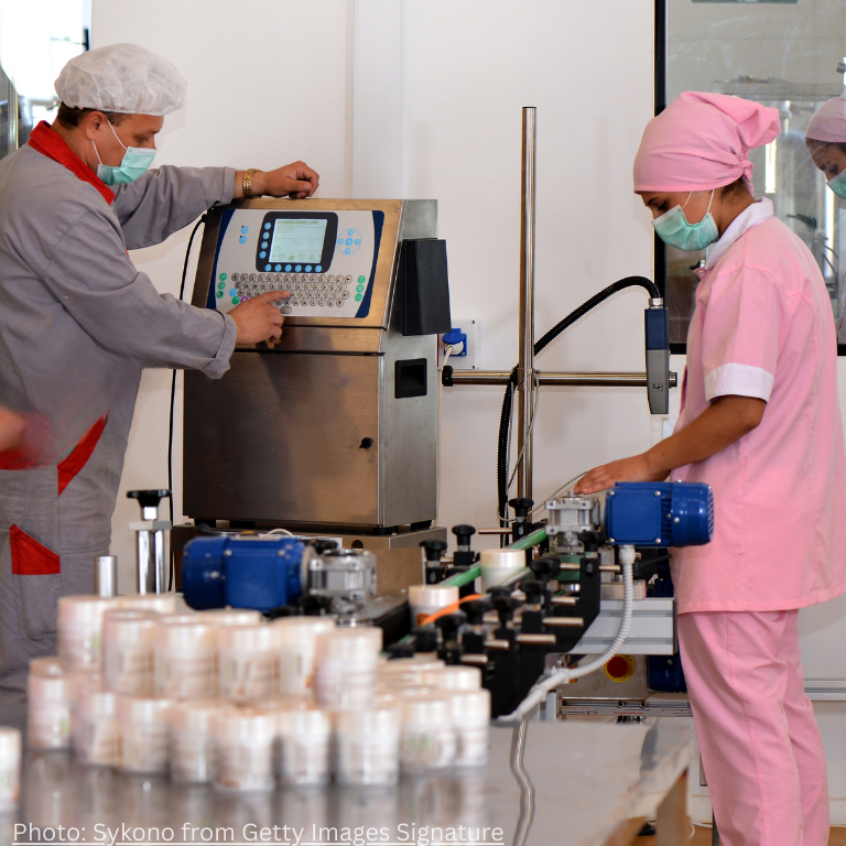 Woman and a man in a cosmetic factory inspecting product