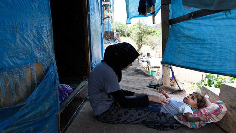 Fatima plays with her son, Mouath in their makeshift home in the Ketermaya refugee camp in Lebanon. © Dominic Chavez/World Bank