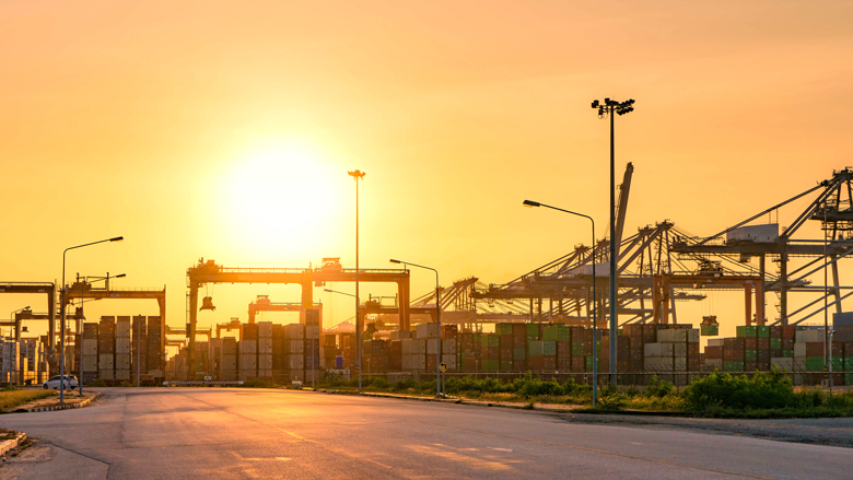 Silhouette. Big crane loading industrial container cargo freight ship for import export logistics. Sunset time. Photo Credit: Red Ivory/Shutterstock