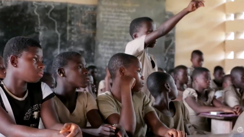 A child raises his hand during class.