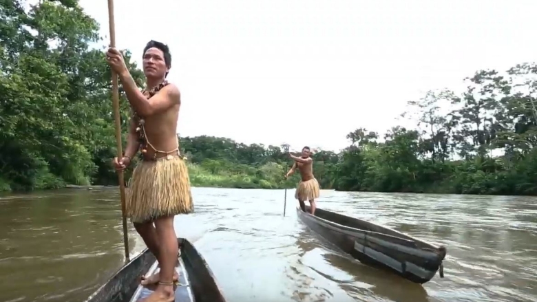 indigenous men in the boat on the river