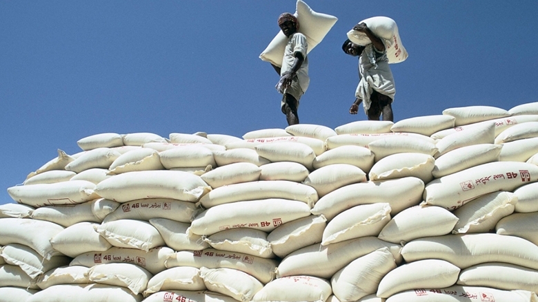 Workers stacking large sacks from a conveyor belt in Pakistan. Photo: Curt Carnemark/World Bank