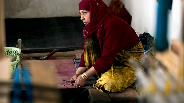 Fifty-year-old Shirin works at weaving a carpet at a carpet and silk weaving center located in the historic Herat Citadel in Afghanistan