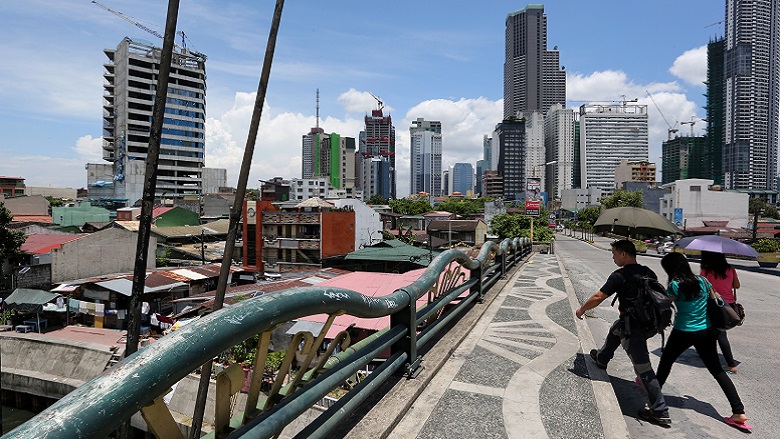 Pedestrians cross over the Pasig River in the City of Makati, Philippines