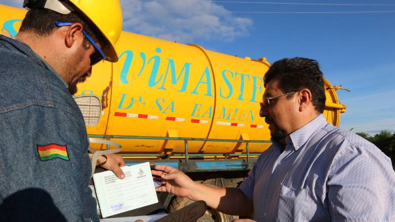 Marco Salinas, the President of the Association of Wastewater Cleaning and Transportation Enterprises, talks with one of his employees.