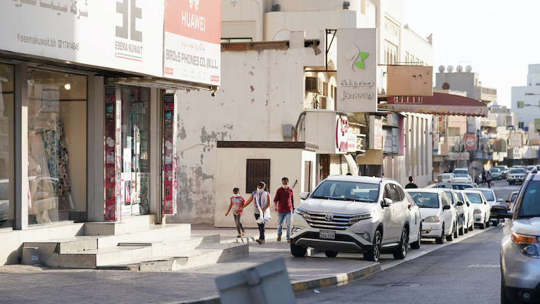 People walk with masks in an old Bahraini town.