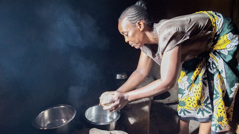 Esther Atieno prepares dinner for her family in Kisumu, Kenya. Her jiko kisasa (firewood stove) uses less fuel than her previous stove. It's also more efficient, giving her time to do bead work for extra income. Photo: Peter Kapuscinski/World Bank