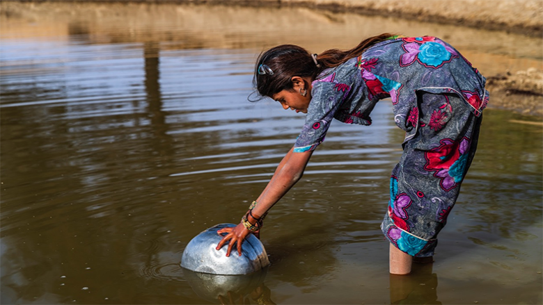 Indian young girl collecting potable water from the local lake,Thar Desert, Rajasthan, India.