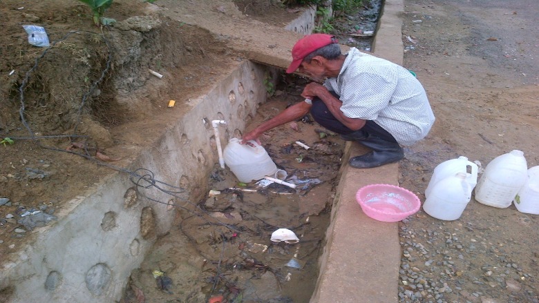 Habitante de Espalliat, República Dominicana recolectando agua. Foto: Corporación del Acueducto y Alcantarillado de Moca (CORAAMOCA)