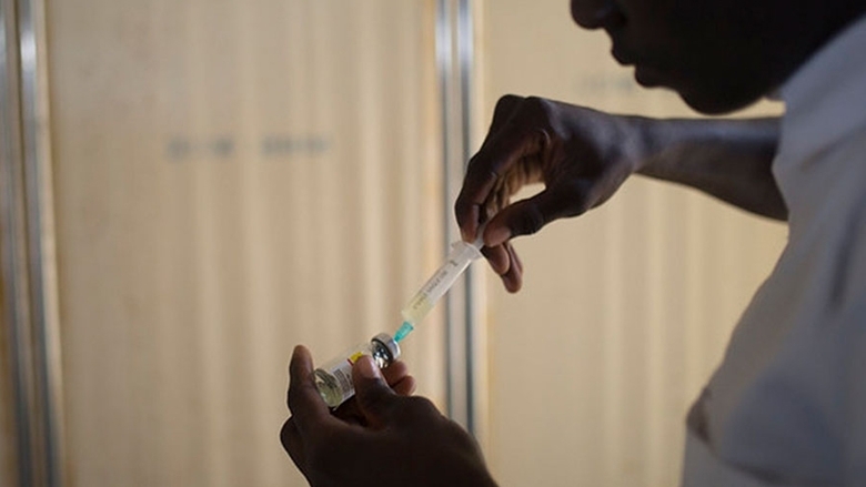 A man fills a syringe from a vial, Nigeria. Photo © Dominic Chavez The Global Financing Facility