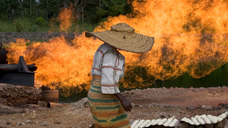 Woman stands near gas flare in Nigeria