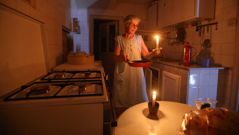 A woman holds a lighted candle after power cuts at her house in Beirut, Lebanon.