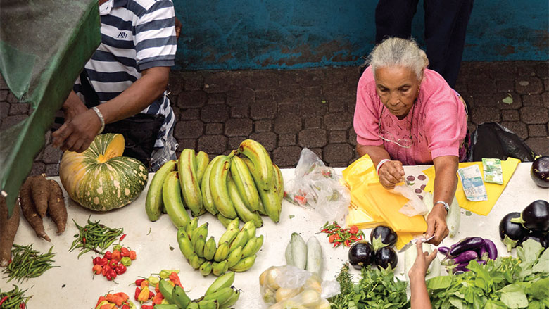 Two women in developing countries selling vegetables - social protection for the informal economy