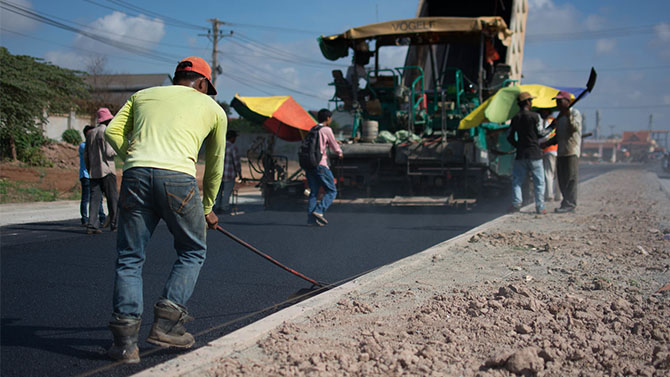 Workers pave a road. Photo credit: Iwan Bagus/IFC