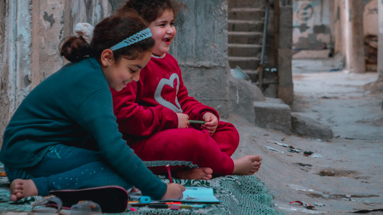 Two Palestinian girls practice their art hobby in front of their house in the Shati refugee camp, west of Gaza. 