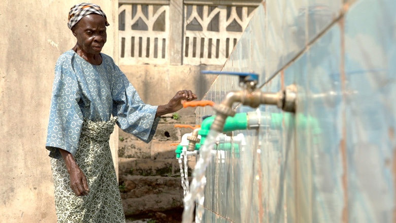 Woman in Ola community fetching clean drinkable water