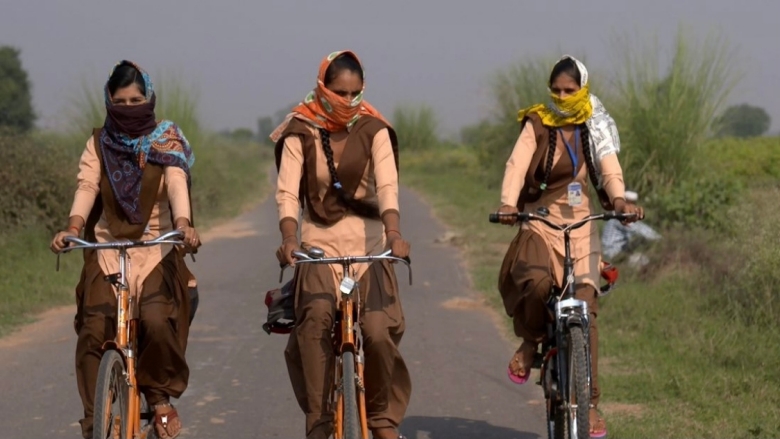 Picture of girls riding bicycles on a rural road 