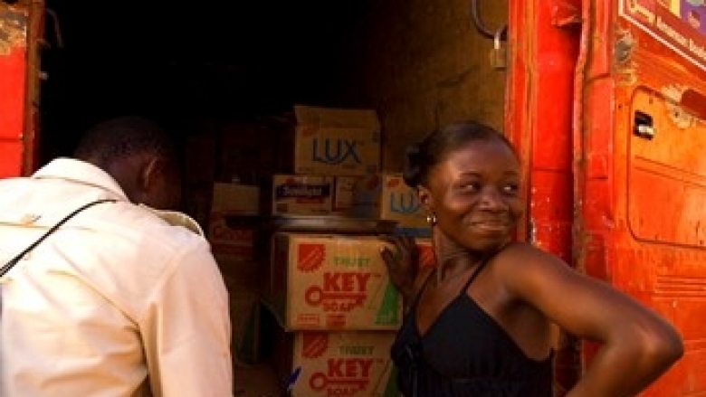 Business woman smiling near a truck filled with boxes near a man