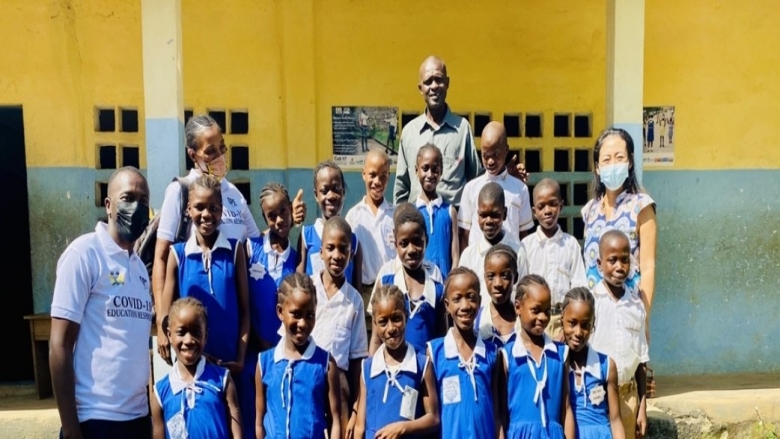 Students and their teacher in front of their school in Freetown Sierra Leone