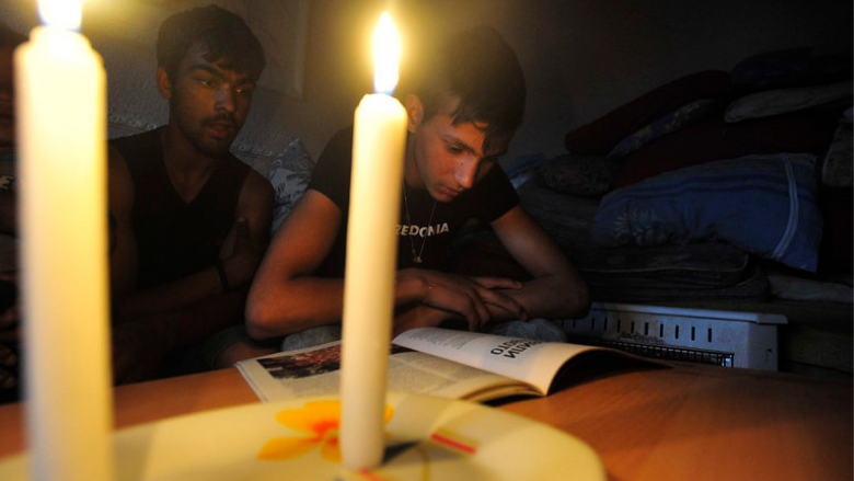 A family reads by candle light following a black out in FYR Macedonia.