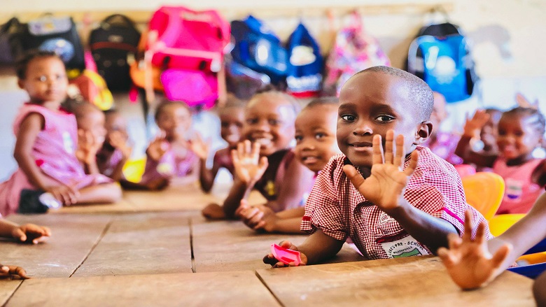 Children smiling at a table in a classroom