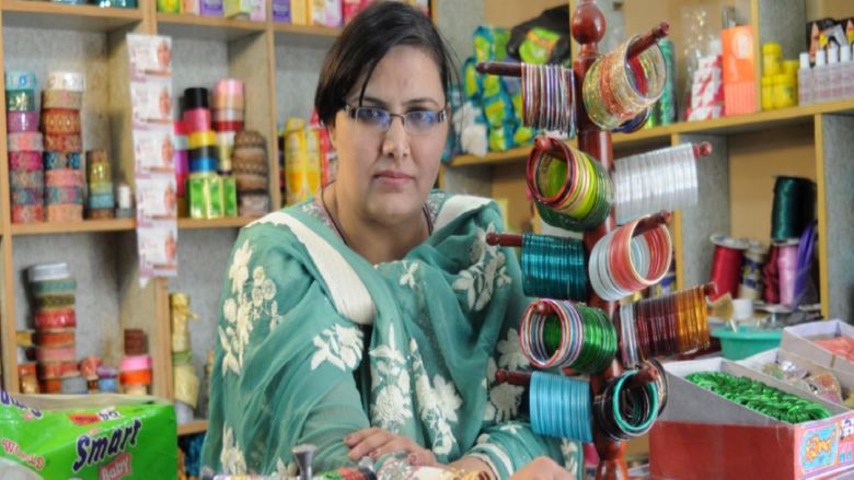 A woman entrepreneur standing behind the counter in her shop