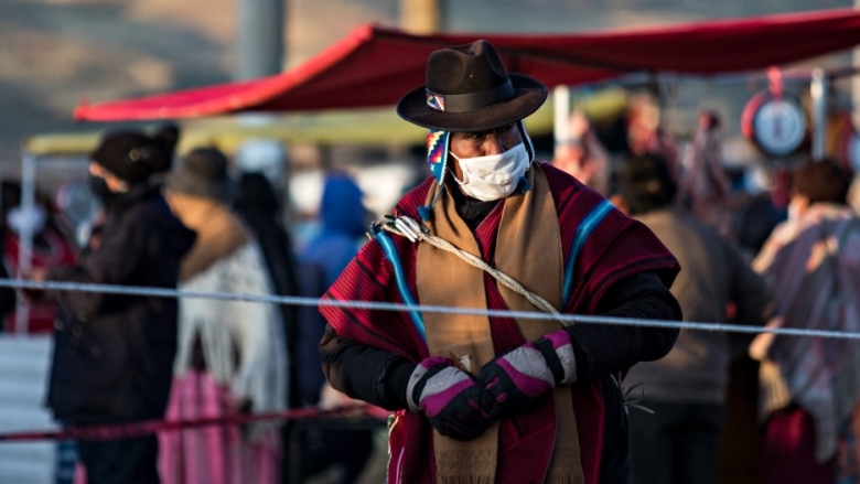 An Aymara man and native authority guards access to a fair in the highlands of Bolivia
