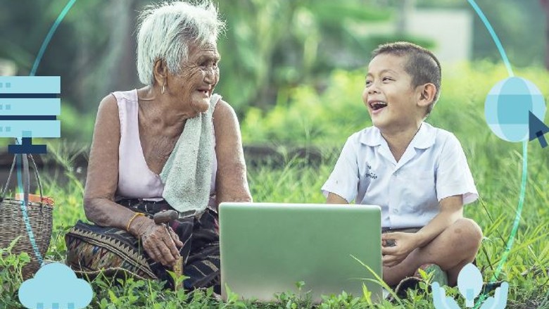 A senior Asian woman smiles at a young boy who is holding a laptop