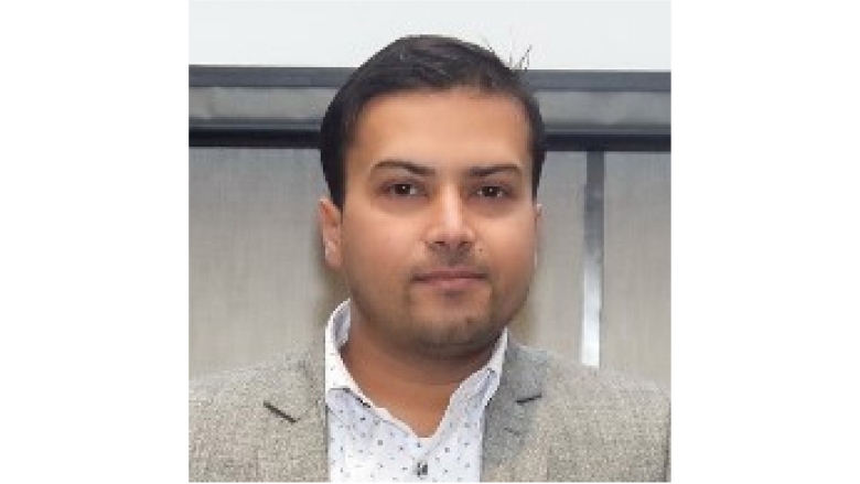 Male with brown hair wearing grey blazer and white blouse