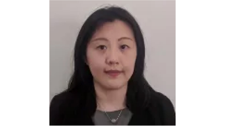 Female with black hair wearing black blazer and grey blouse
